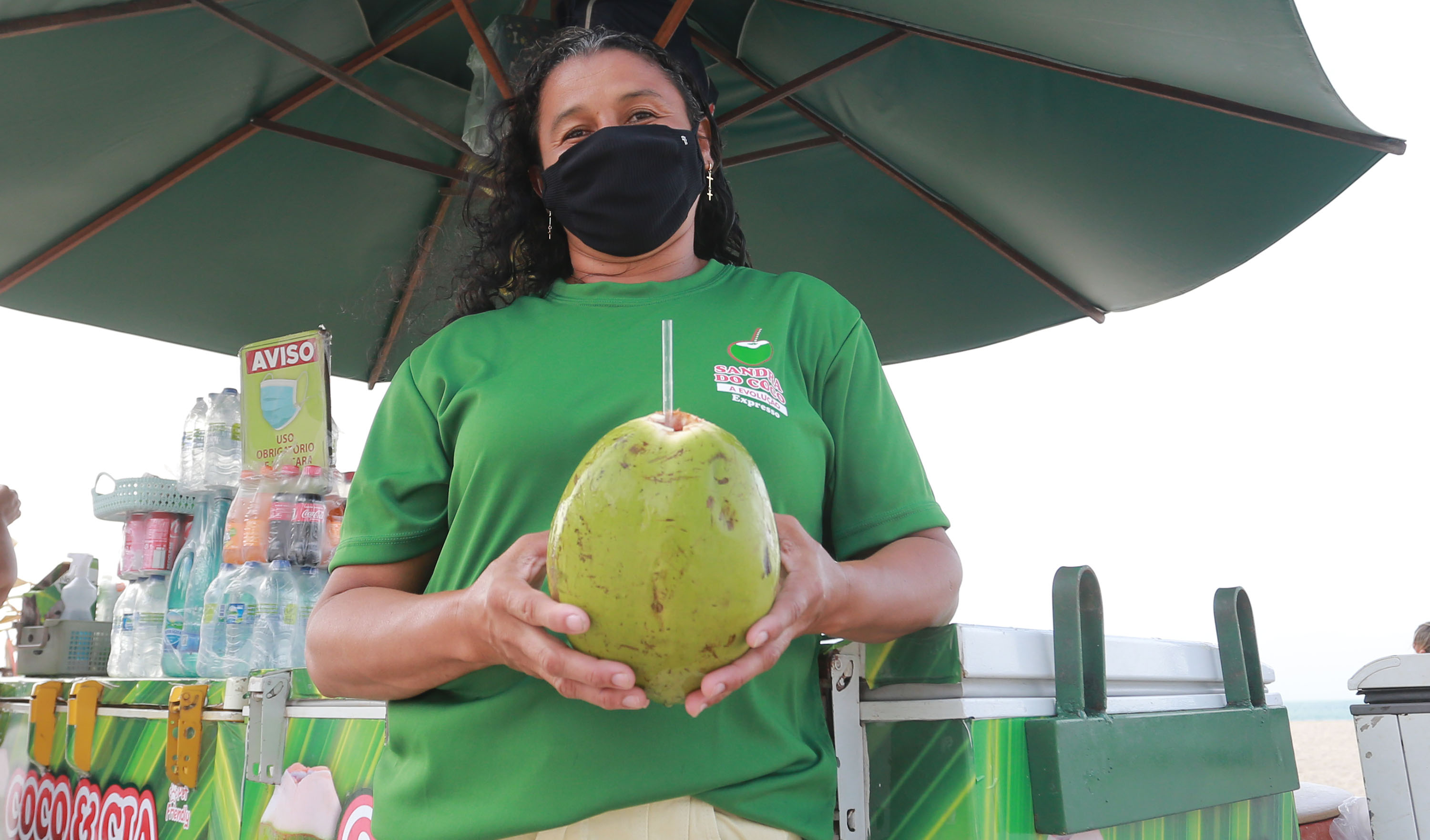 Sandra posa para a foto segurando um coco